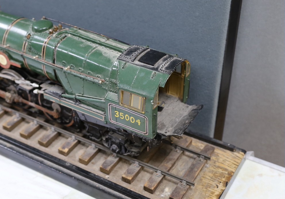 A scratch built scale model ‘S.R./B.R. Modified ‘Merchant Navy’ Class 3 CYL. 4.6.2 Locomotive No.35004 ‘Cunard-White Star’’ and carriage on track. Track length 94.5cm